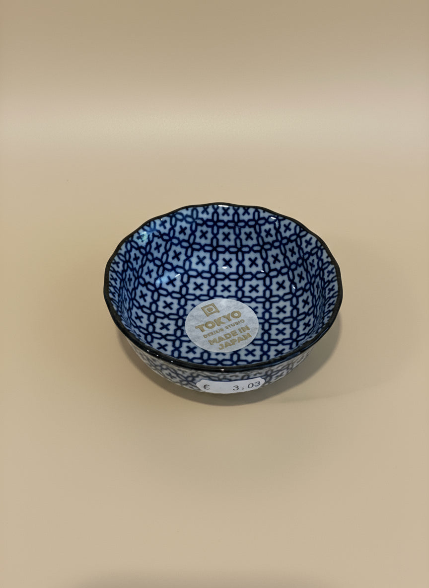 Round blue and white patterned container on a wooden surface