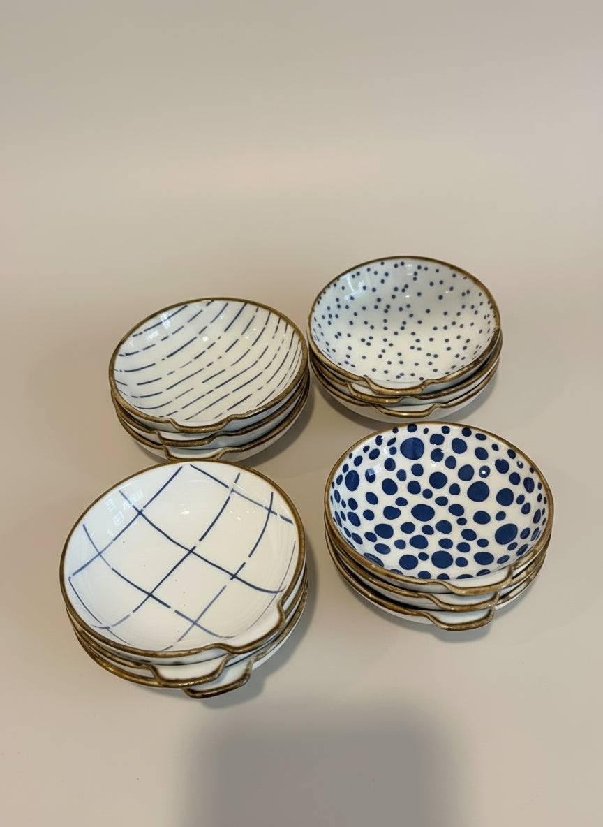 Four ceramic bowls with different patterns on a wooden surface